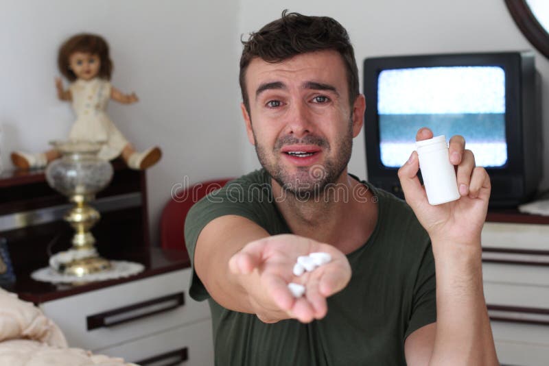 Uomo emozionale che tiene alcune pillole fotografie stock libere da diritti Uomo emozionale che tiene alcune pillole fotografie stock libere da diritti