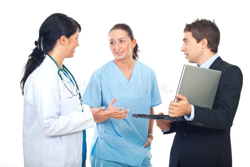 Young executive man holding a laptop and having a conversation with two physicians women. Young executive man holding a laptop and having a conversation with two physicians women