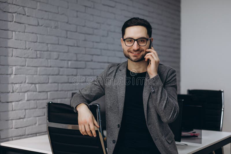 Uomo esecutivo sorridente barbuto del lavoratore della giovane brunetta bella attraente nel posto di lavoro della stazione del la immagini stock libere da diritti Uomo esecutivo sorridente barbuto del lavoratore della giovane brunetta bella attraente nel posto di lavoro della stazione del la immagini stock libere da diritti