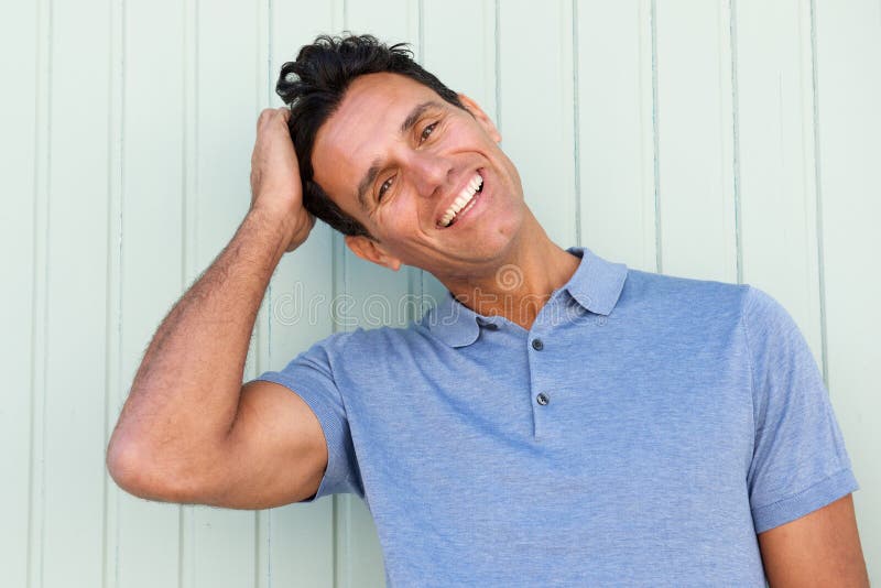 Uomo felice di medio evo che ride con la mano in capelli immagine stock