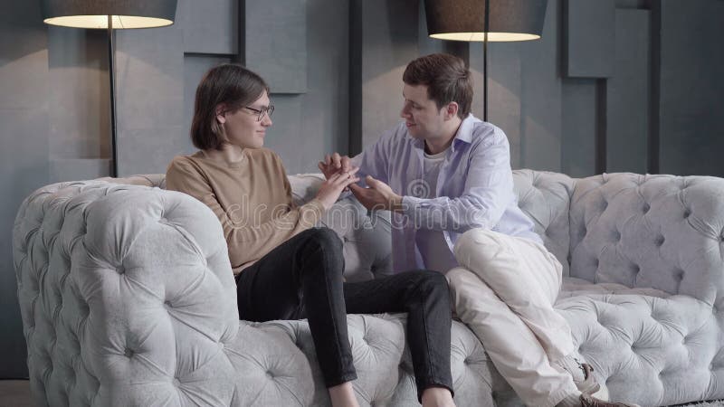 Uomo felice e sicuro di sé che mette la fede sul dito del compagno di sesso maschile. ritratto di un giovane omosessuale caucasico archivi video