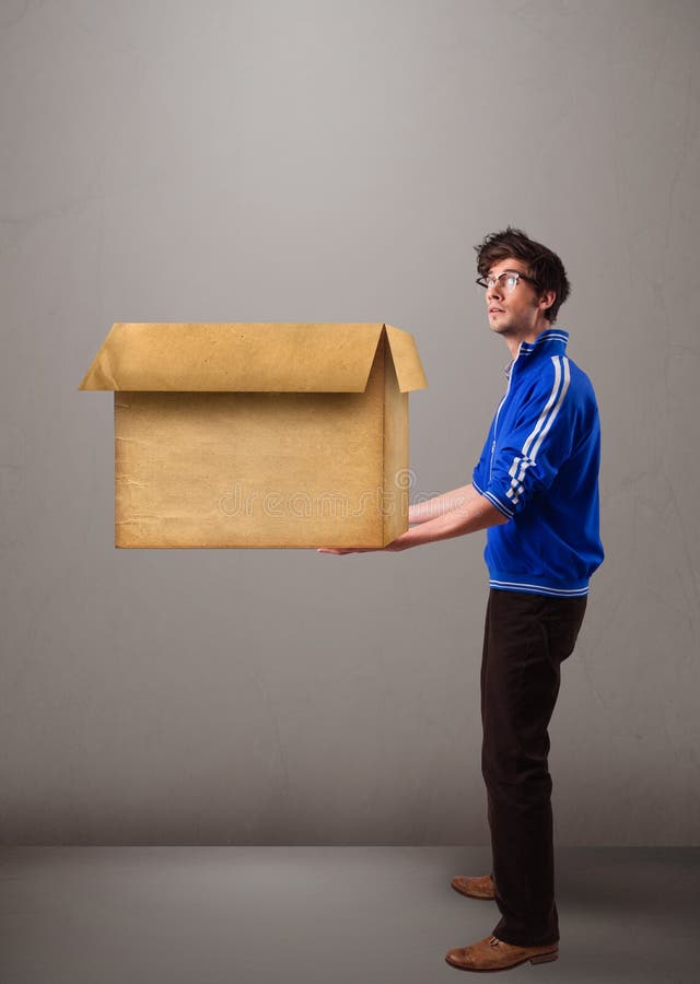 uomo Goog di aspetto che tiene una scatola di cartone marrone vuota immagini stock uomo Goog di aspetto che tiene una scatola di cartone marrone vuota immagini stock