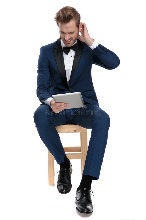 Uomo infelice nelle cattive notizie blu della lettura dello smoking dal blocco note immagini stock Uomo infelice nelle cattive notizie blu della lettura dello smoking dal blocco note immagini stock