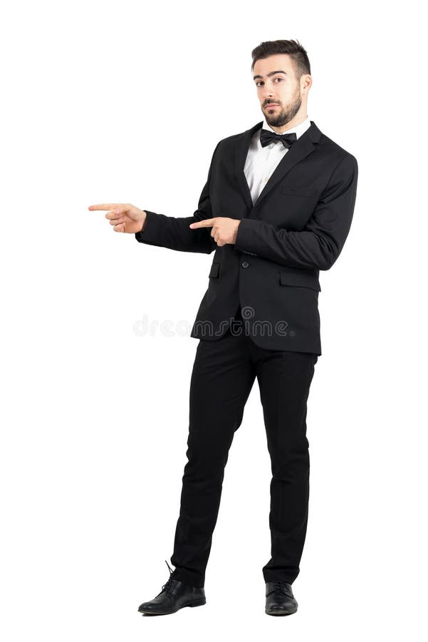 Uomo lussuoso confuso con il farfallino che indica al copyspace immagini stock Uomo lussuoso confuso con il farfallino che indica al copyspace immagini stock