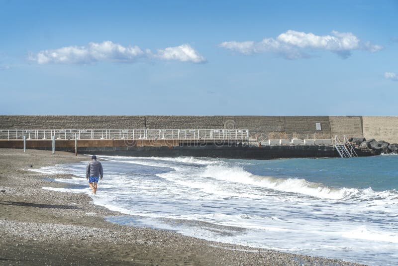 Uomo maggiore che cammina lungo il percorso dal mare fotografie stock libere da diritti Uomo maggiore che cammina lungo il percorso dal mare fotografie stock libere da diritti