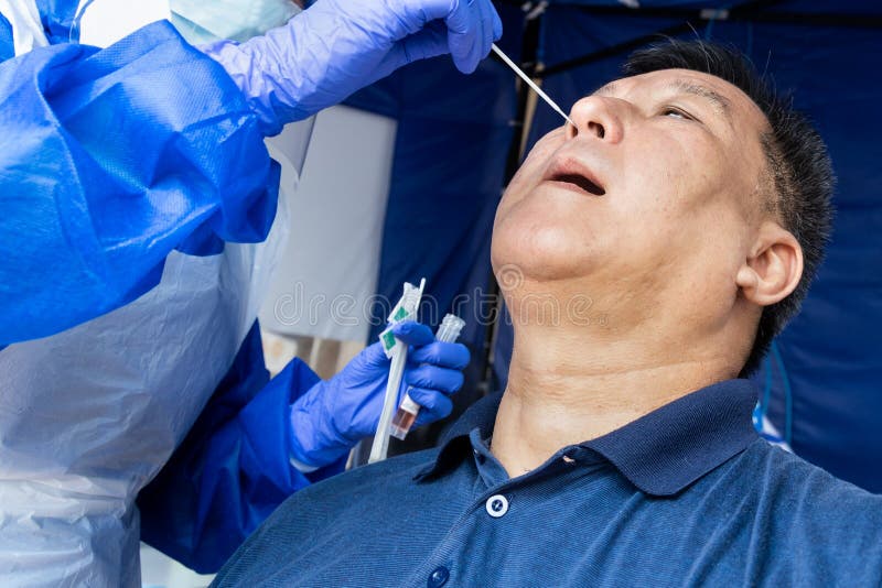 Mature asian man doing covid 19 PCR nasal swab test via nostril at hospital testing center. Mature asian man doing covid 19 PCR nasal swab test via nostril at hospital testing center