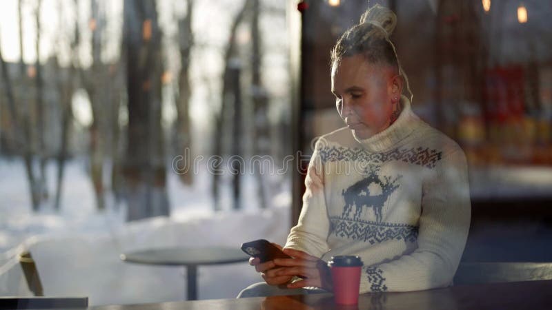 Uomo moderno ed elegante con orologeria siede al bar in inverno e beve tè caldo stock footage