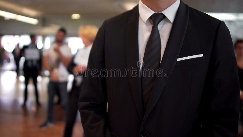 Uomo negli arrivi aspettanti del vestito nel corridoio dell'aeroporto, agente di viaggi, turismo fotografia stock Uomo negli arrivi aspettanti del vestito nel corridoio dell'aeroporto, agente di viaggi, turismo fotografia stock