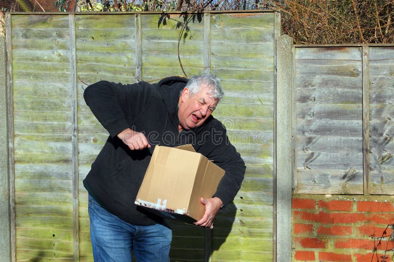 Uomo nel dolore che porta scatola pesante fotografie stock libere da diritti Uomo nel dolore che porta scatola pesante fotografie stock libere da diritti