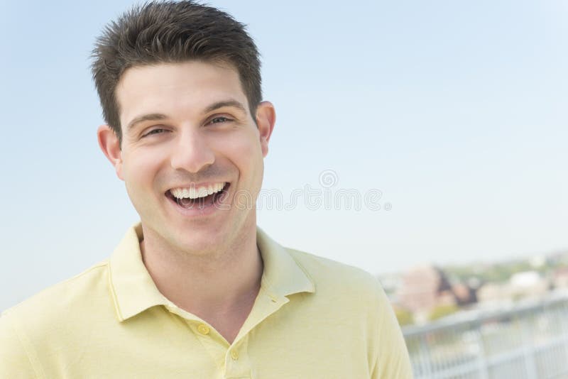 Uomo nella risata casuale contro il cielo chiaro fotografia stock libera da diritti Uomo nella risata casuale contro il cielo chiaro fotografia stock libera da diritti