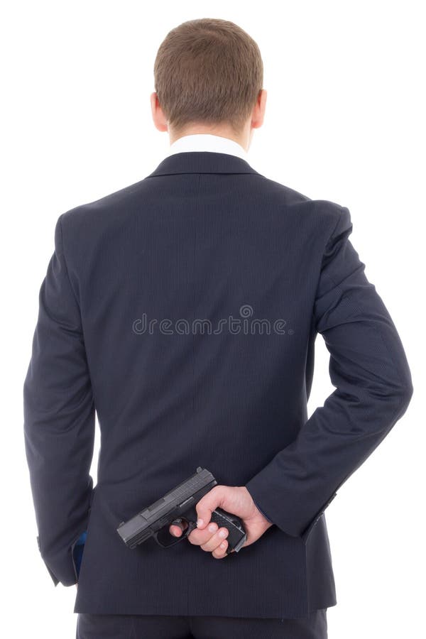 Man in business suit hiding gun behind his back isolated on white background. Man in business suit hiding gun behind his back isolated on white background