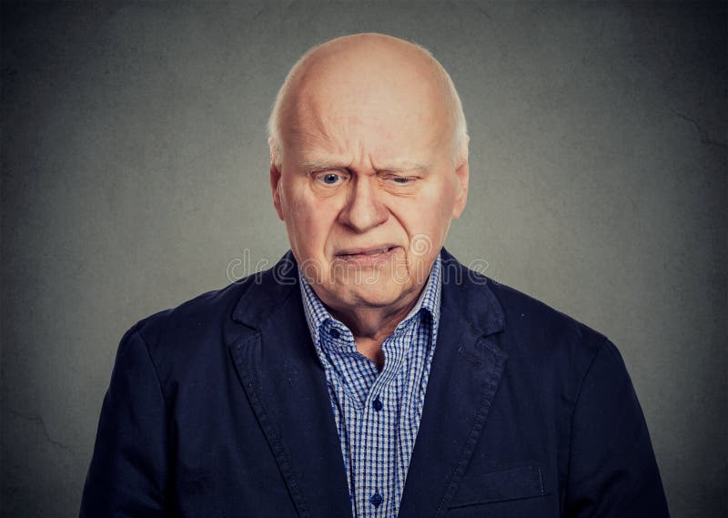 Uomo scettico triste anziano che guarda giù immagine stock Uomo scettico triste anziano che guarda giù immagine stock