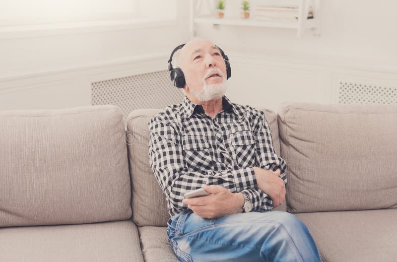 Uomo senior che ascolta la musica con le cuffie immagine stock libera da diritti Uomo senior che ascolta la musica con le cuffie immagine stock libera da diritti