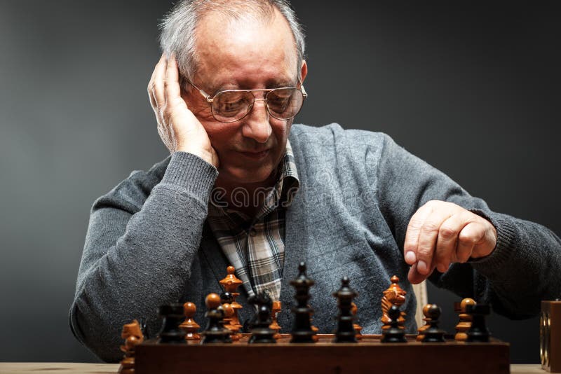 Uomo senior che pensa alla sua prossima tappa in un gioco di scacchi