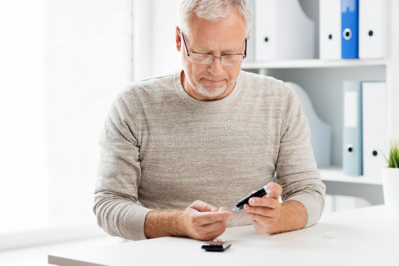 Uomo senior con il glucometer che controlla glicemia fotografie stock Uomo senior con il glucometer che controlla glicemia fotografie stock