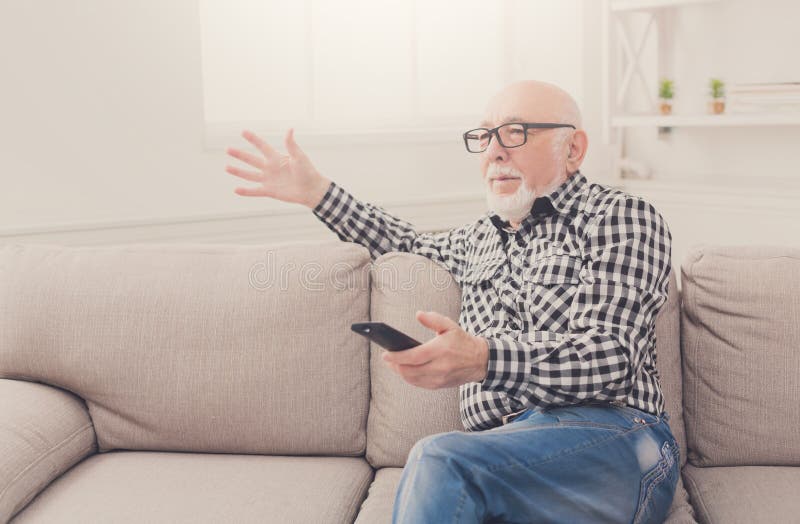 Uomo senior emozionale che guarda TV copiare spazio fotografie stock libere da diritti Uomo senior emozionale che guarda TV copiare spazio fotografie stock libere da diritti