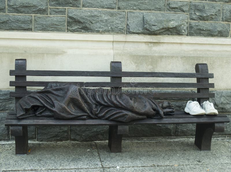 Uomo senza casa che dorme sul banco