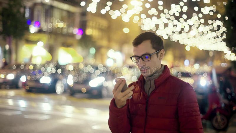 Uomo Sms che manda un sms facendo uso del App sullo Smart Phone alla città