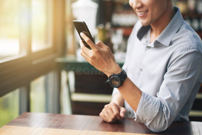 Uomo sorridente che manda un sms con gli amici fotografie stock libere da diritti