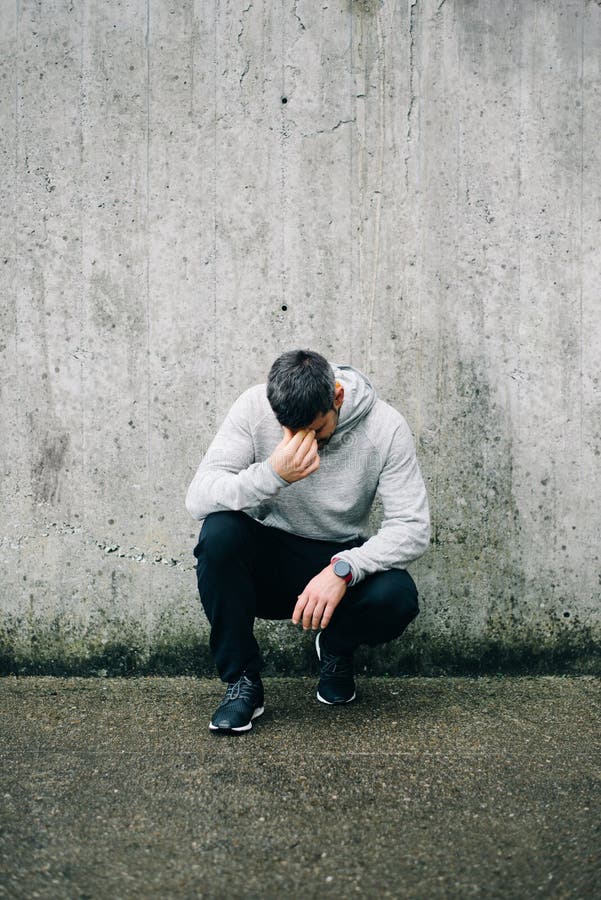 Uomo sportivo stanco che riposa durante l'allenamento all'aperto urbano immagini stock libere da diritti Uomo sportivo stanco che riposa durante l'allenamento all'aperto urbano immagini stock libere da diritti
