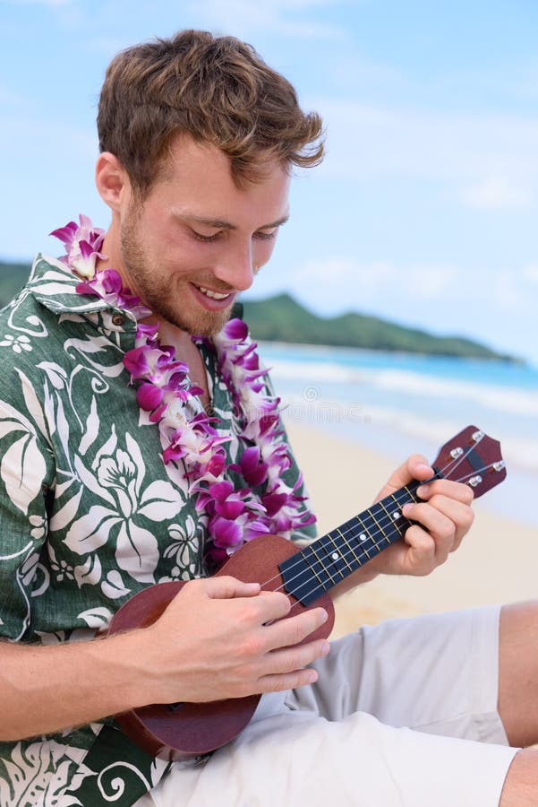 Uomo sulla spiaggia hawaiana che gioca ukulele sulle Hawai fotografie stock libere da diritti Uomo sulla spiaggia hawaiana che gioca ukulele sulle Hawai fotografie stock libere da diritti