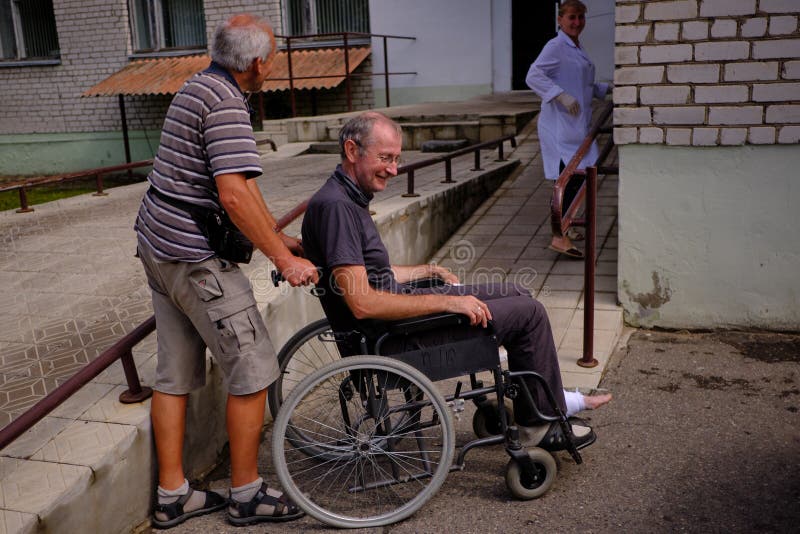 uomo in una sedia a rotelle al pronto soccorso dell'ospedale della città fotografia stock uomo in una sedia a rotelle al pronto soccorso dell'ospedale della città fotografia stock