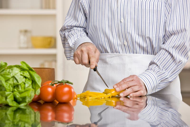 Uomo utile che prepara insalata in cucina fotografia stock Uomo utile che prepara insalata in cucina fotografia stock