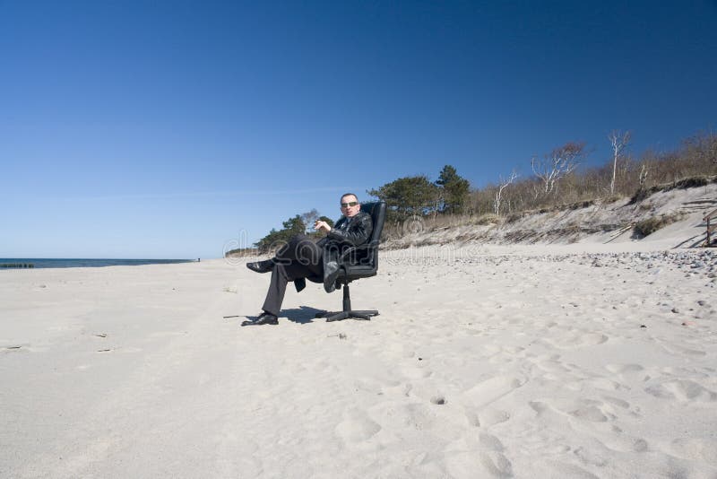 Uomo in vestito che si distende sulla spiaggia fotografia stock libera da diritti Uomo in vestito che si distende sulla spiaggia fotografia stock libera da diritti