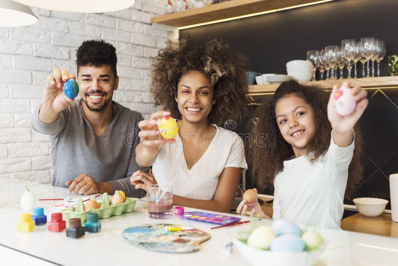Uova afroamericane felici di coloritura della famiglia immagini stock libere da diritti Uova afroamericane felici di coloritura della famiglia immagini stock libere da diritti
