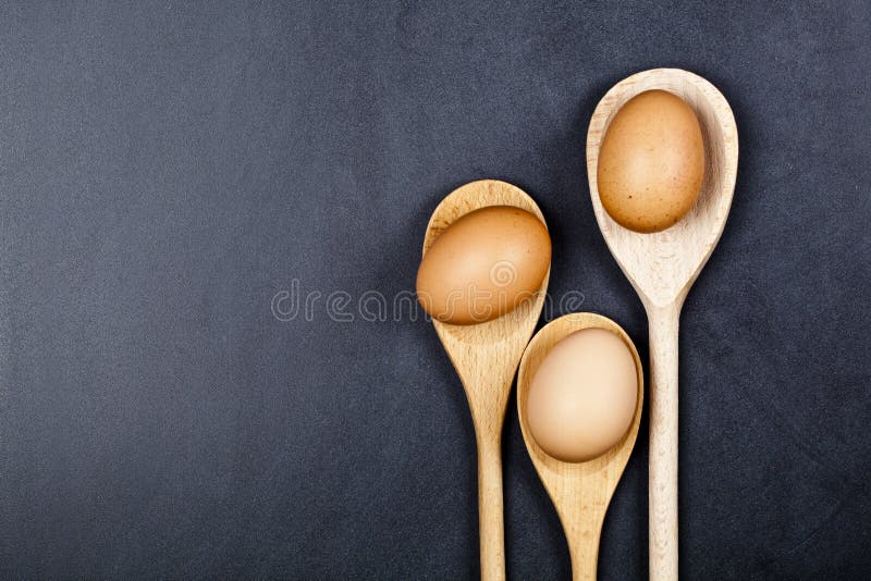 Uova in cucchiai di legno fotografie stock libere da diritti Uova in cucchiai di legno fotografie stock libere da diritti