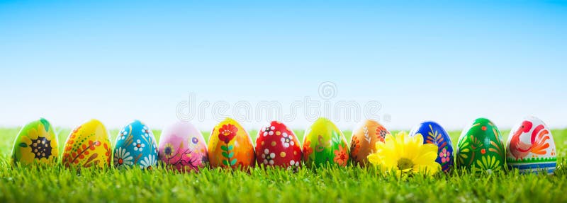 Uova di Pasqua dipinte a mano variopinte su erba Insegna, panoramica