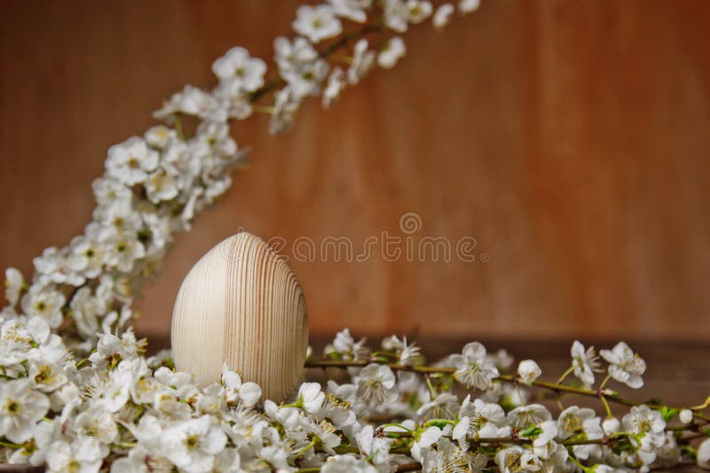 Uova di Pasqua di legno fra i rami di fioritura della ciliegia su una tavola rustica composizione simbolica della festa della mol fotografia stock libera da diritti Uova di Pasqua di legno fra i rami di fioritura della ciliegia su una tavola rustica composizione simbolica della festa della mol fotografia stock libera da diritti