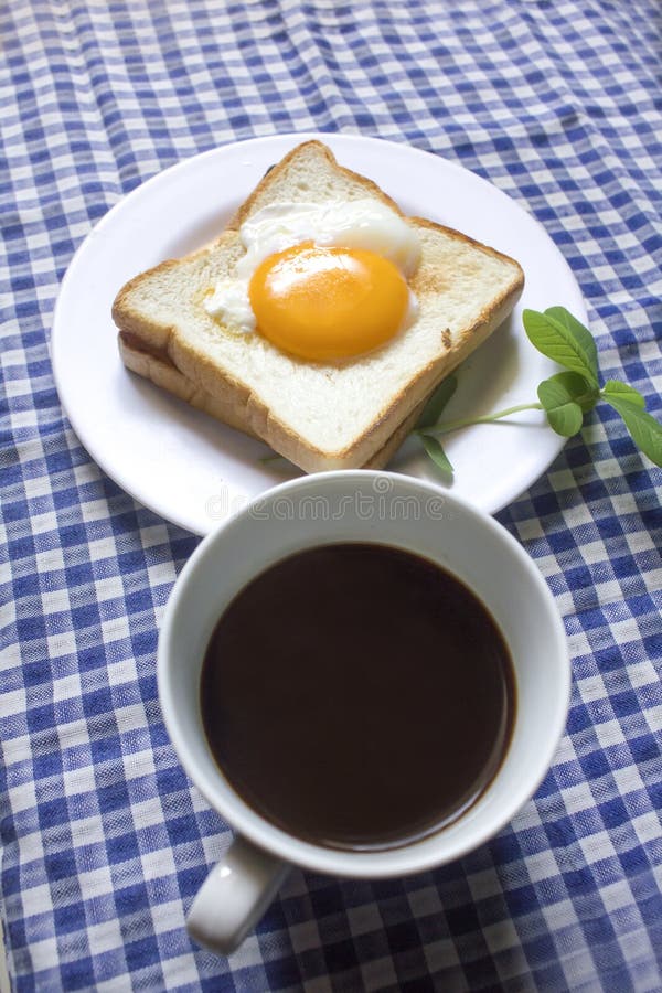 Uovo fritto su pane tostato e su caffè nero in un vetro fotografie stock libere da diritti Uovo fritto su pane tostato e su caffè nero in un vetro fotografie stock libere da diritti