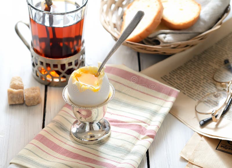 Uovo à la coque della prima colazione con un tè, uno zucchero bruno e un pane fragranti fotografia stock Uovo à la coque della prima colazione con un tè, uno zucchero bruno e un pane fragranti fotografia stock