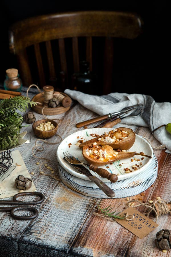 Upieczone gruszki pocięte na pół rycotą, granolą, orzechami sosnowymi na płycie ceramicznej zdjęcie stock Upieczone gruszki pocięte na pół rycotą, granolą, orzechami sosnowymi na płycie ceramicznej zdjęcie stock