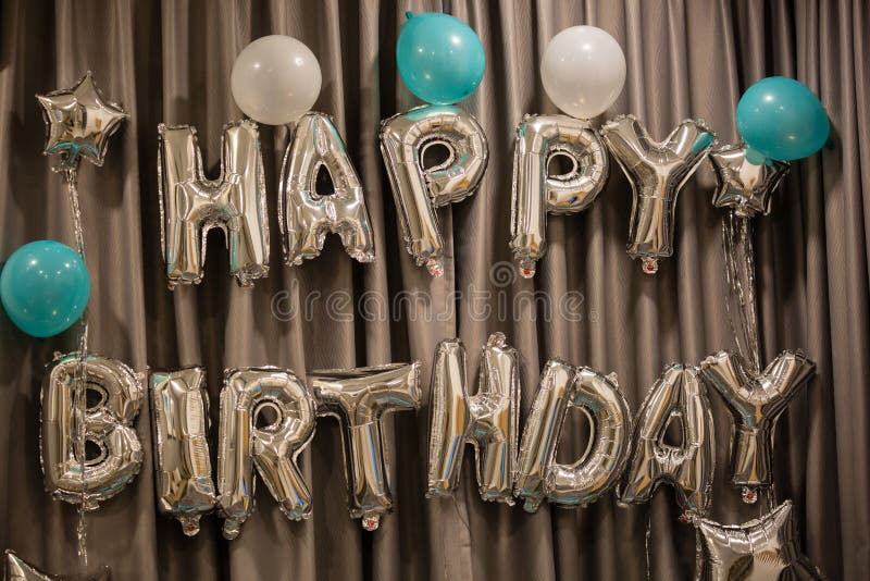 Upper case letters HAPPY BIRTHDAY from silver balloons view stock photography