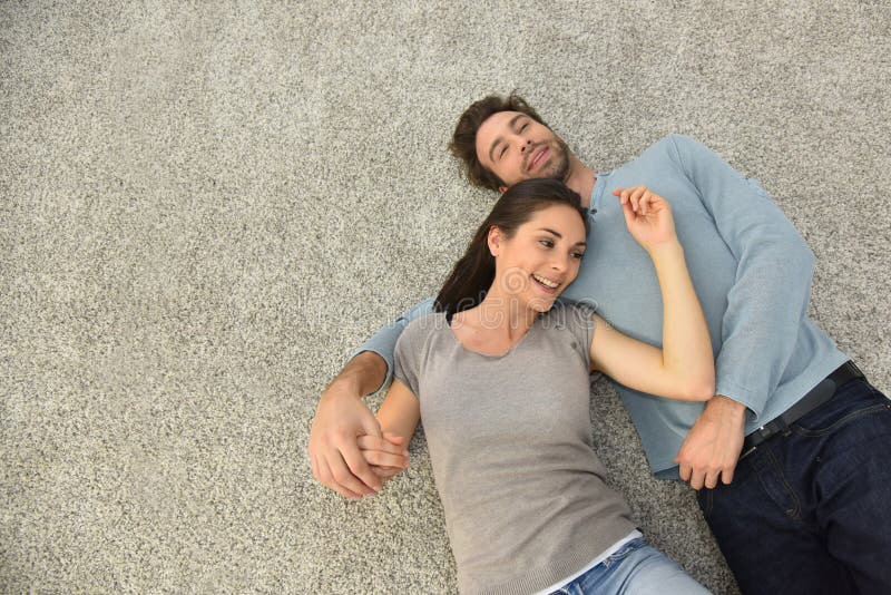 Upper view of couple lying on carpet floor stock photos