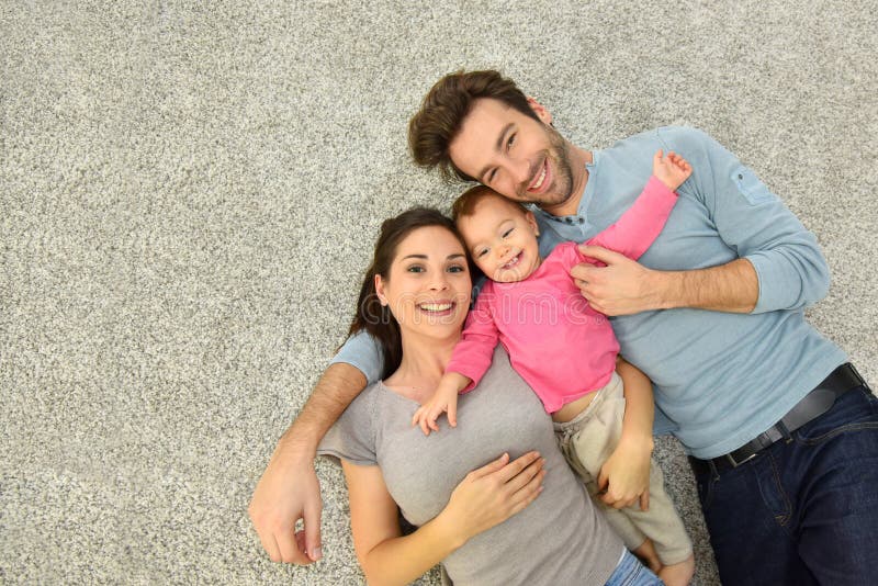 Upper view of family of three laying on carpet floor royalty free stock photo