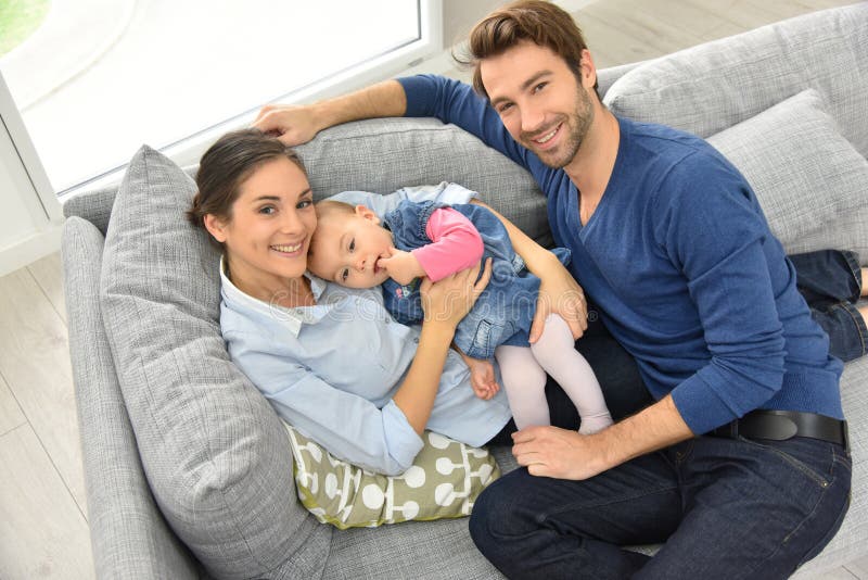 Upper view of happy young family lying on sofa stock photos