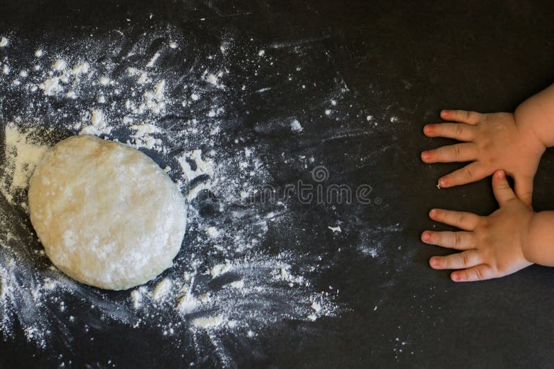Upper view of a risen yeast dough for pizza or bread with toddlers hands stock photo