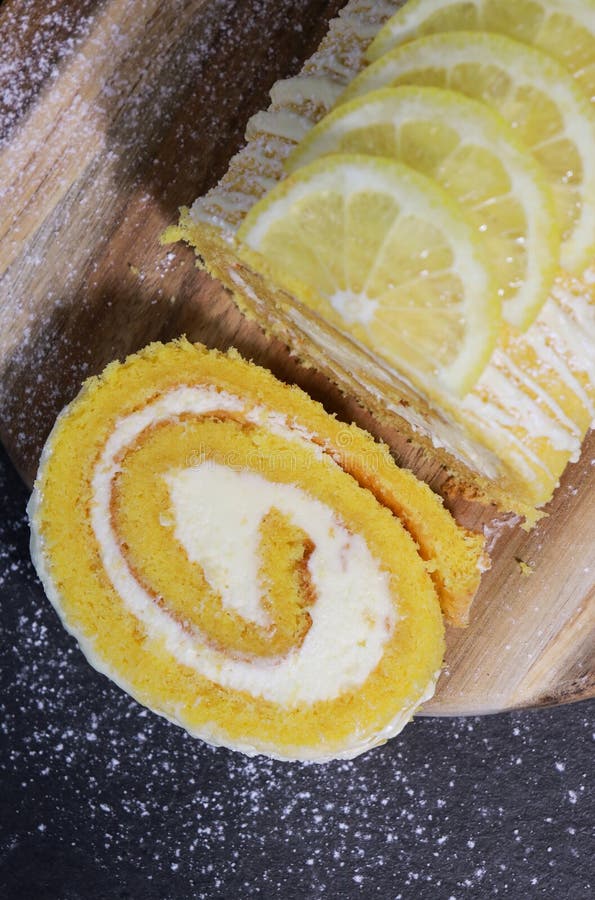 Upper view of a vanilla cake roll with lemon butter cream, dark grey marble table royalty free stock images
