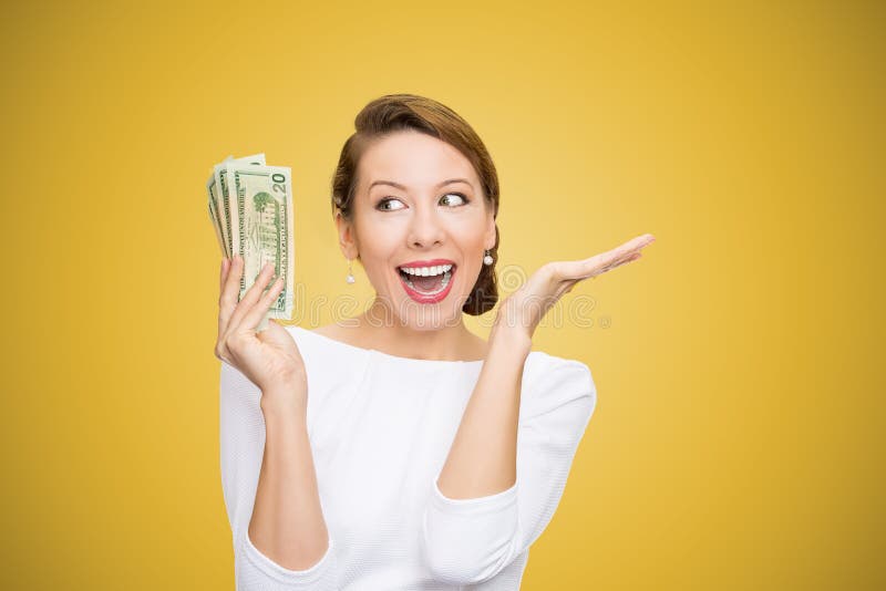 Upphetsad kvinnainnehavhög av dollar som ser toppet lyckligt på ljus gul bakgrund