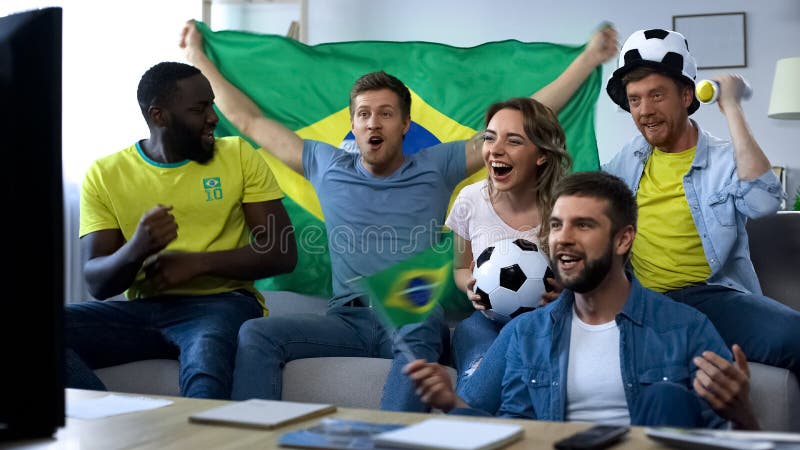 Upphetsade brasilianska vänner som hurrar för landslaget som firar segra mål arkivbilder Upphetsade brasilianska vänner som hurrar för landslaget som firar segra mål arkivbilder