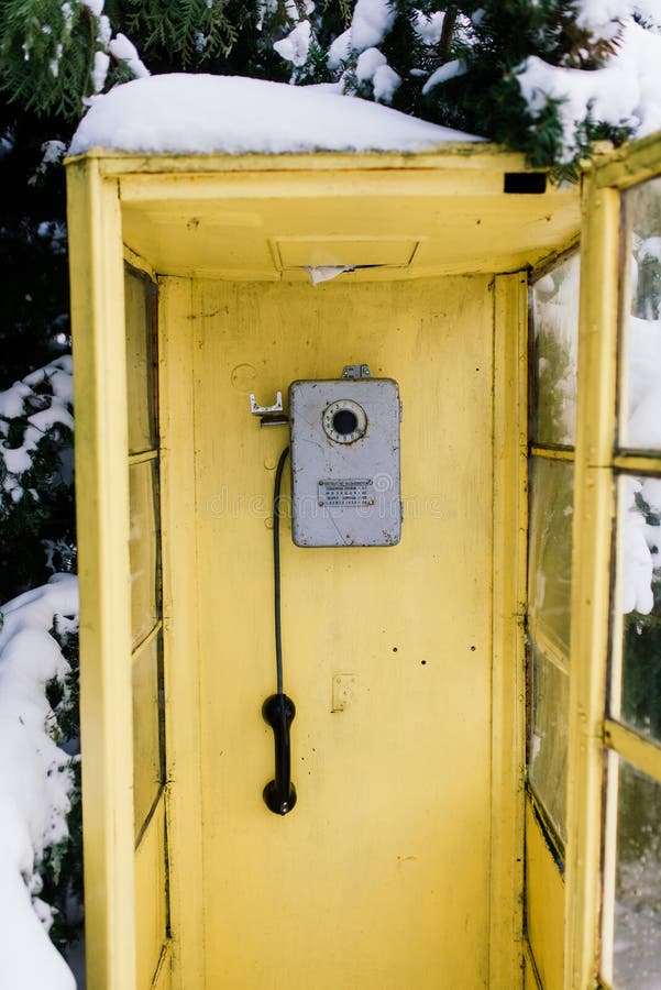Uppringningsruta för årgång i vinterstadsparkens vinterlandskap. Vintage callbox i vinterstadsparkens vinterlandskap
