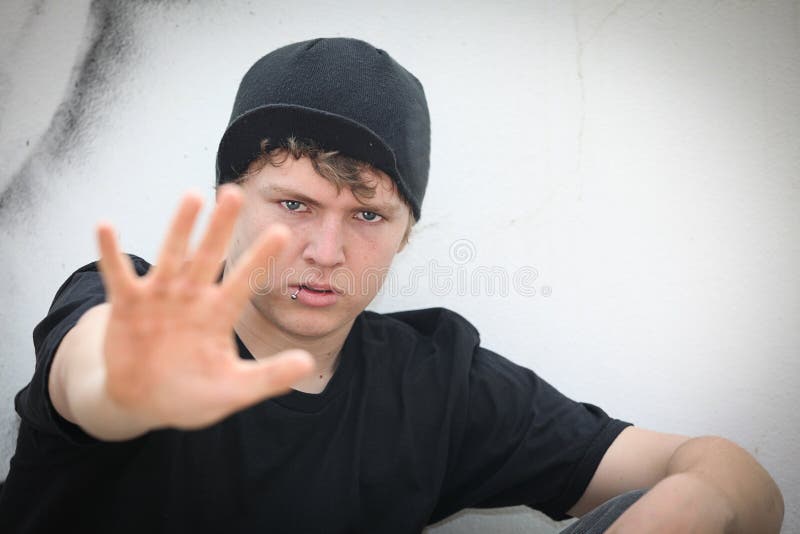 Rebellious teen boy holding palm out. Rebellious teen boy holding palm out