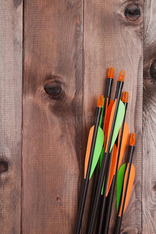 Set of arrows for the sports of archery on a wooden background. Set of arrows for the sports of archery on a wooden background