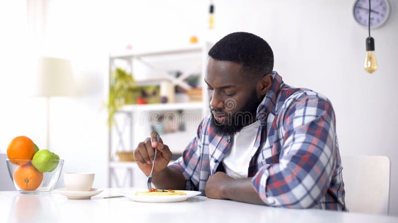 Upset Afro-American male eating spaghetti on lunch, relationship crisis, problem