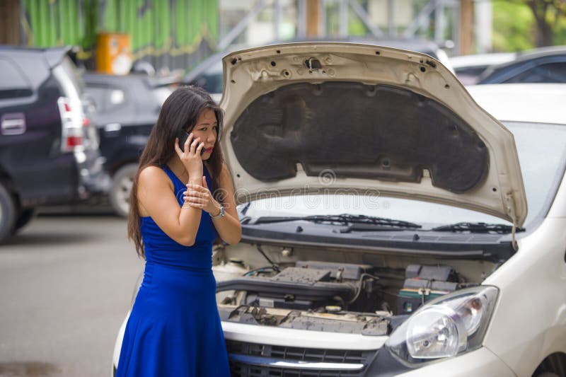 Upset Asian Japanese woman in stress stranded on street suffering car engine failure having mechanic problem calling on mobile royalty free stock images Upset Asian Japanese woman in stress stranded on street suffering car engine failure having mechanic problem calling on mobile royalty free stock images