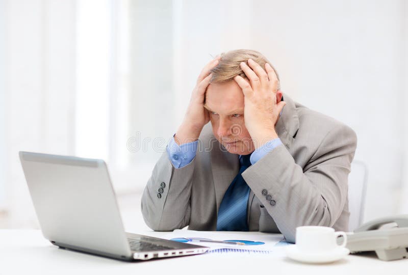 Upset older businessman with laptop and telephone royalty free stock photo Upset older businessman with laptop and telephone royalty free stock photo