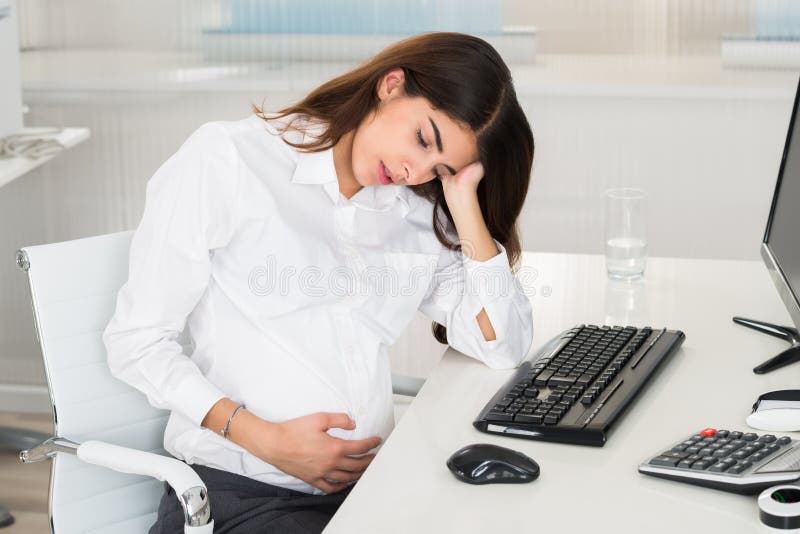 Upset Pregnant Woman Sitting At Computer Desk royalty free stock images Upset Pregnant Woman Sitting At Computer Desk royalty free stock images